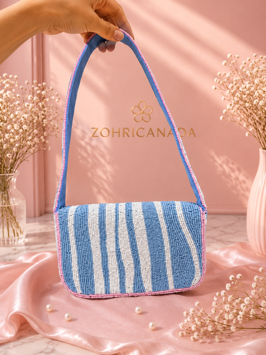 Seaside Bikini Handmade Beaded Shoulder Bag — Blue and white striped beaded shoulder bag with pink trim by ZOHRICANADA, styled on a pink satin background with pearls and dried flowers — Zohricanada
